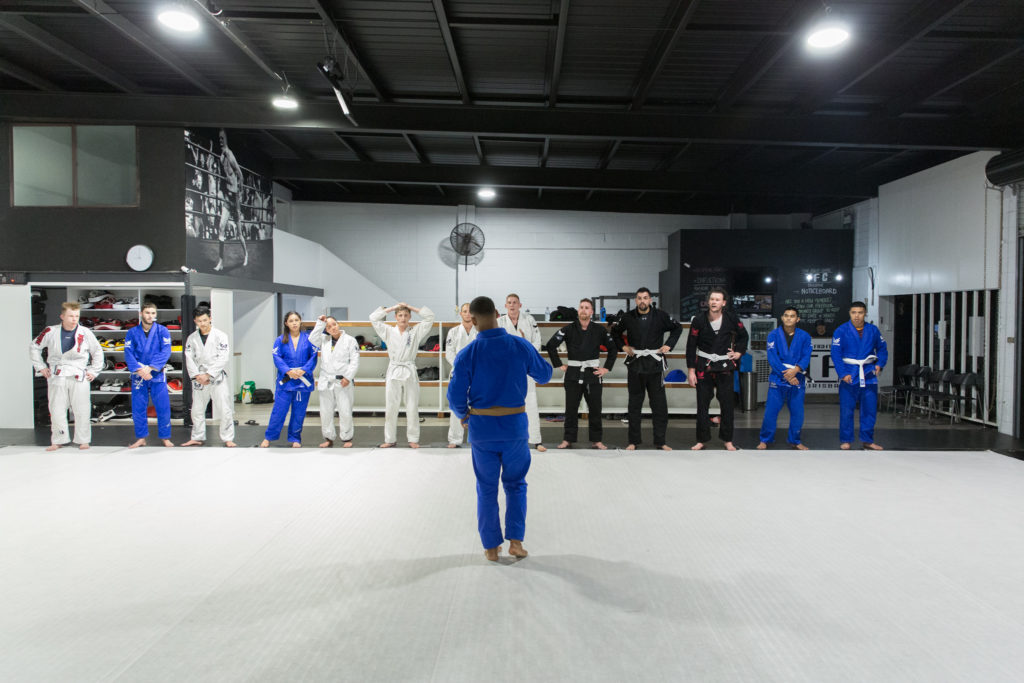 Students line up to greet their coach before the BJJ class starts.