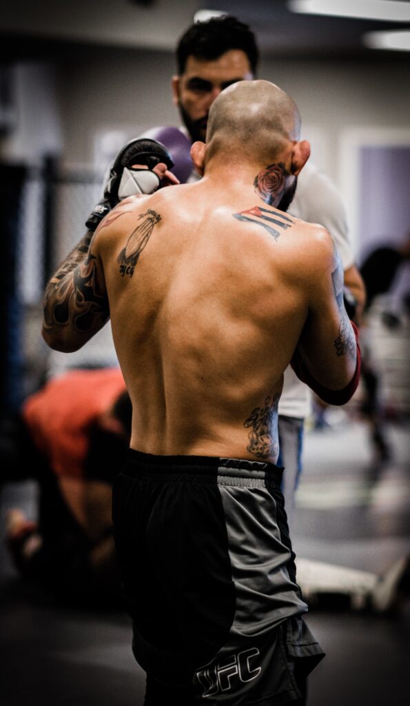 View from behind of an MMA fighter training with his partner