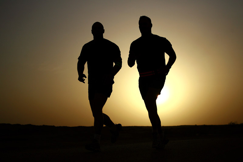 Two people going for a run as sunrise.