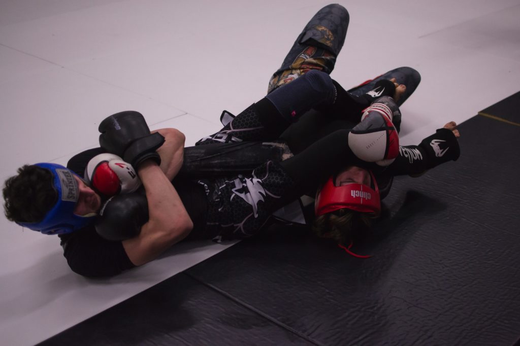 2 MMA athletes grappling on the mat