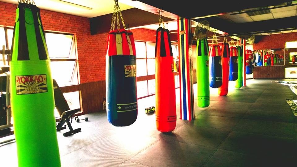 colourful heavy bags line a gym floor